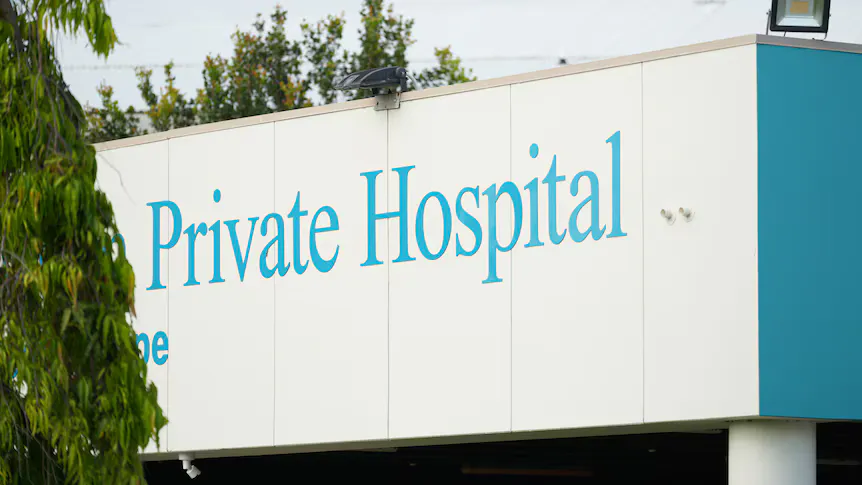 An empty hospital room with a bed and medical equipment