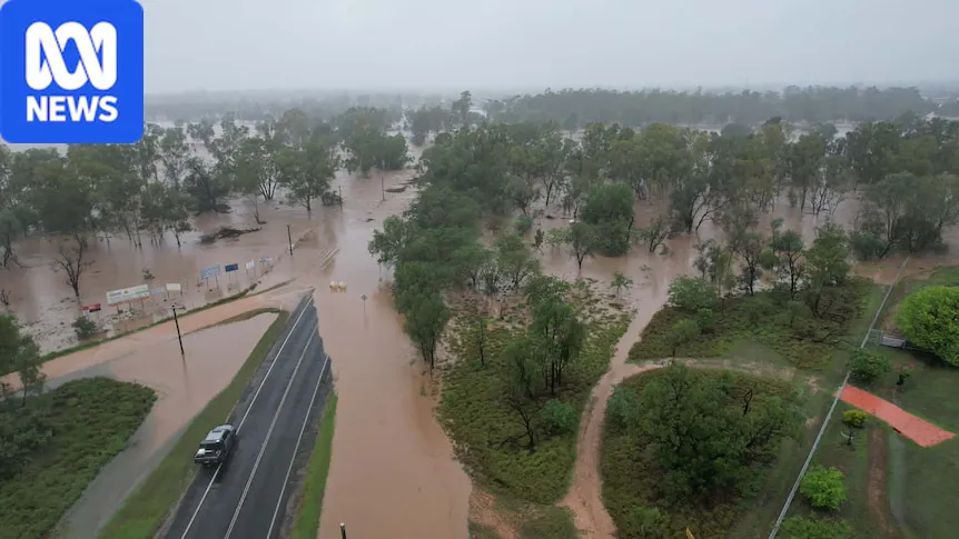 Floodwater covering a road beside buildings in a regional town