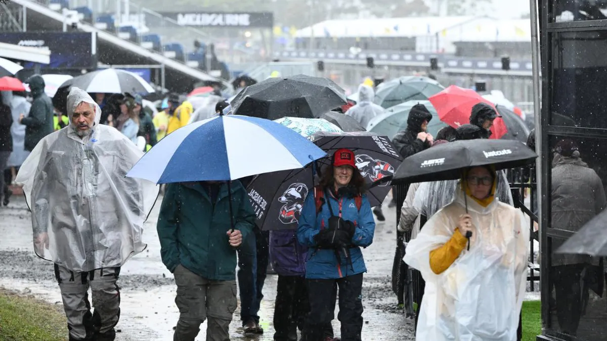 A wet motorcycle racing circuit with safety barriers and grandstands