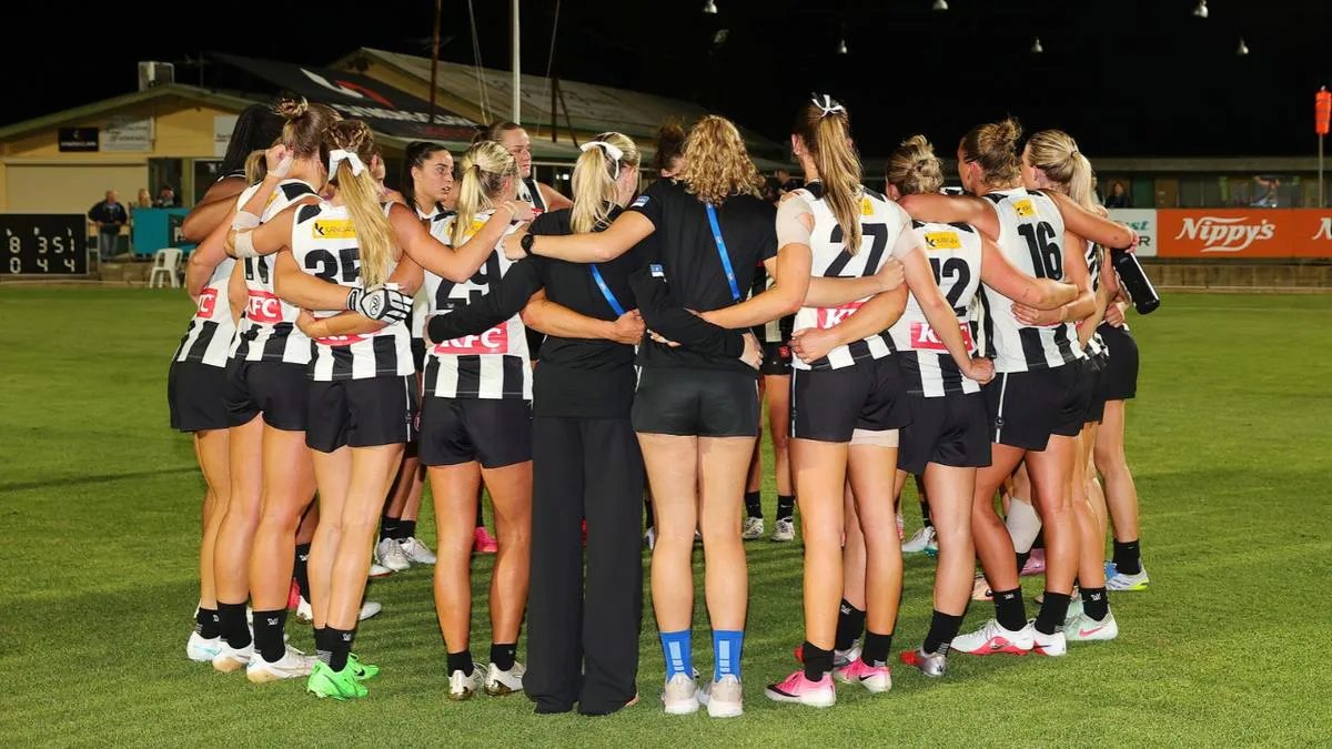 Australian rules football on an oval beside boundary markings