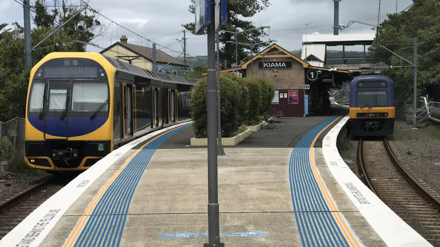 Railway tracks and overhead electrical wires beside a station platform