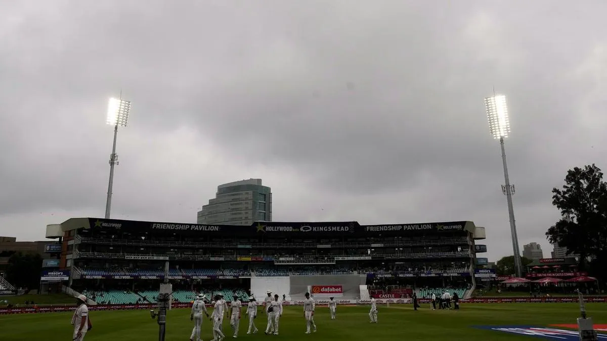 Floodlights illuminating a cricket ground under cloudy skies